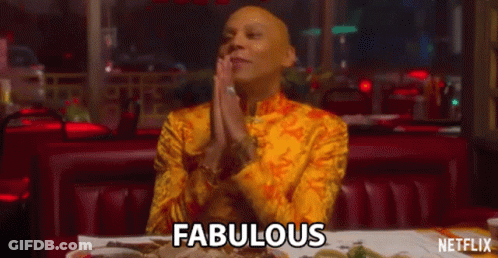 A Man In A Yellow Shirt Is Sitting At A Table In A Restaurant With His Hands Folded . GIF