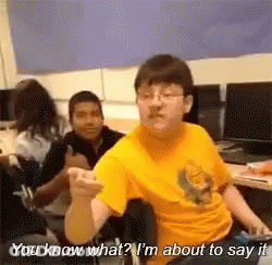 A Man In A Yellow Shirt Is Sitting In A Chair And Talking To Another Man . GIF