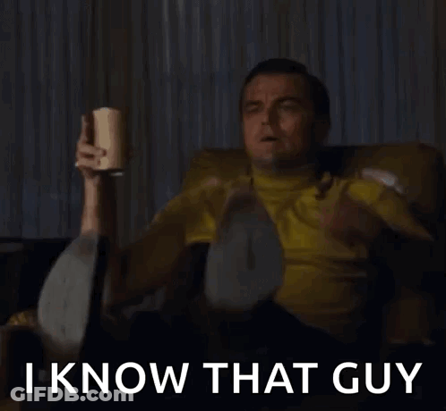 A Man In A Yellow Shirt Is Sitting On A Couch Holding A Bottle And Saying I Know That Guy . GIF