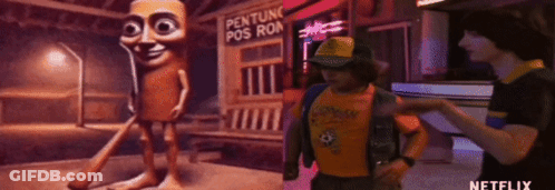 A Man In A Yellow Shirt Is Standing Next To A Cartoon Character In Front Of A Sign That Says Penture Pos Ron . GIF