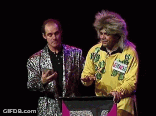 A Man In A Yellow Shirt Is Standing Next To A Man In A Silver Suit And Says " Vous Pouvez Repeter La Question " GIF
