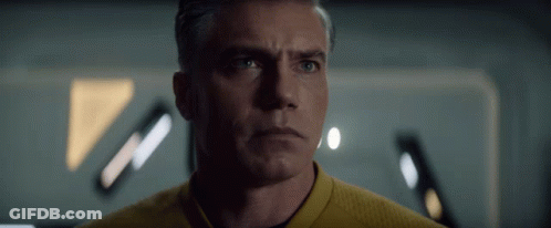 A Man In A Yellow Shirt Looks At The Camera With A Serious Look On His Face GIF