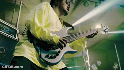 A Man In A Yellow Shirt Plays A Guitar GIF