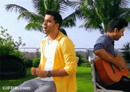 A Man In A Yellow Shirt Sings While Another Man Plays Guitar GIF