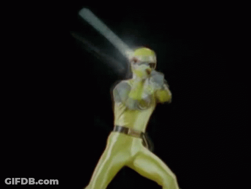 A Man In A Yellow Superhero Costume Is Holding A Light In His Hand . GIF
