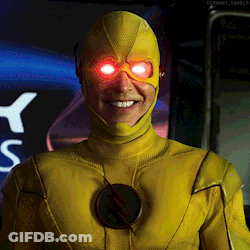 A Man In A Yellow Superhero Suit Has Red Eyes GIF