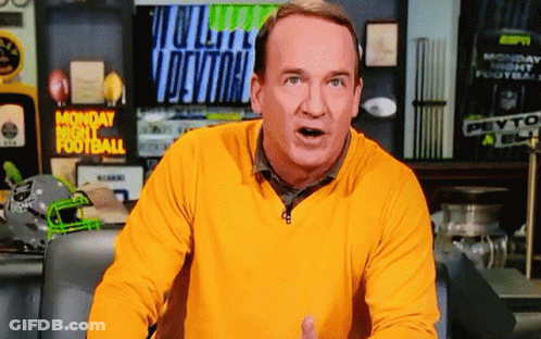 A Man In A Yellow Sweater Stands In Front Of A Monday Night Football Screen GIF