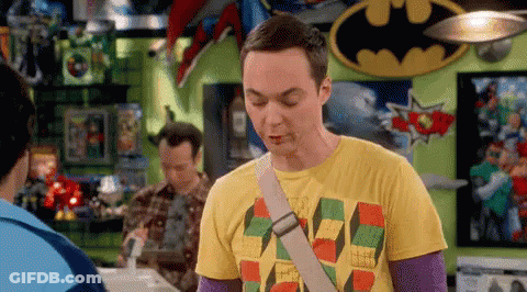A Man In A Yellow T-Shirt Is Standing In A Room With A Batman Sign . GIF