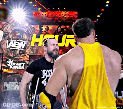 Man In Yellow Tank Talking To Another In Front Of Hour Sign GIF