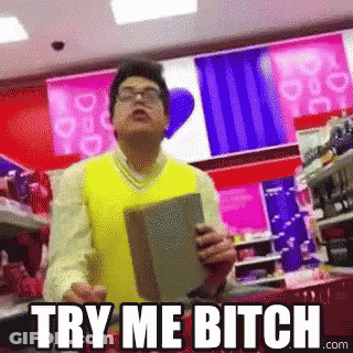 A Man In A Yellow Vest Is Holding A Book In Front Of A Sign That Says Try Me Bitch GIF