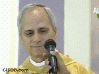 A Man In A Yellow Vest Is Holding A Microphone In His Hand GIF