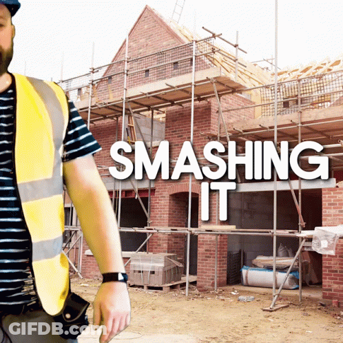 A Man In A Yellow Vest Stands In Front Of A Building Under Construction With The Words Smashing It Behind Him GIF
