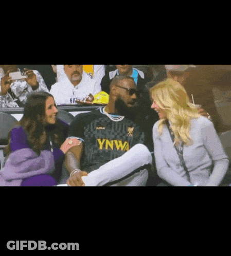 A Man In A Ynwa Jersey Is Talking To A Woman GIF