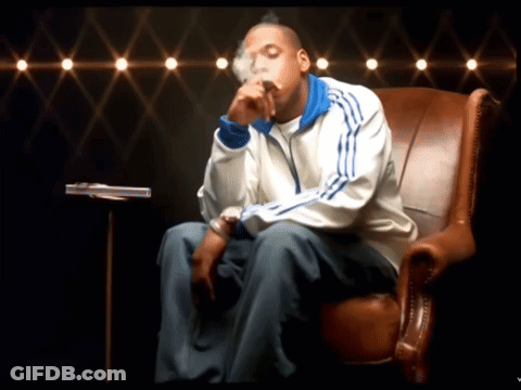 A Man In An Adidas Jacket Sits In A Chair GIF