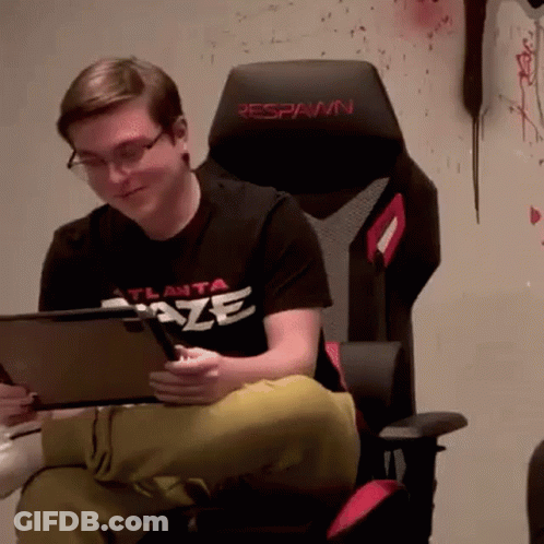 A Man In An Atlanta Blaze Shirt Is Sitting In A Chair GIF