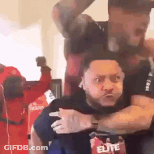 A Man In An Elite Shirt Is Carrying Another Man On His Shoulders GIF