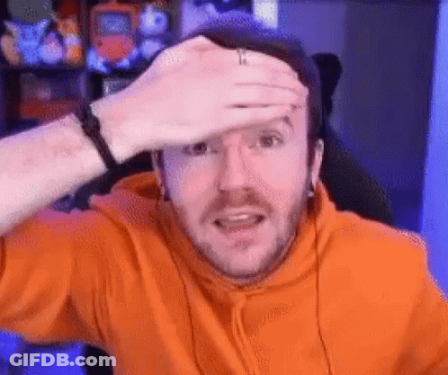 A Man In An Orange Hoodie Is Holding His Hand To His Forehead And Making A Funny Face . GIF