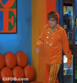 A Man In An Orange Jacket And Striped Pants Is Dancing GIF