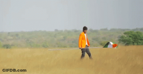 A Man In An Orange Jacket Is Holding An Indian Flag GIF