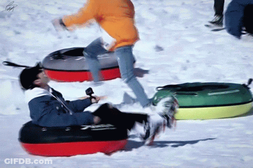 A Man In An Orange Jacket Is Riding A Red And Black Tube GIF