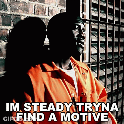 A Man In An Orange Jumpsuit Is Standing In Front Of A Brick Wall With The Words Im Steady Tryna Find A Motive Below Him GIF