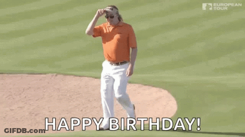 A Man In An Orange Shirt And White Pants Is Standing On A Baseball Field And Says `` Happy Birthday '' . GIF