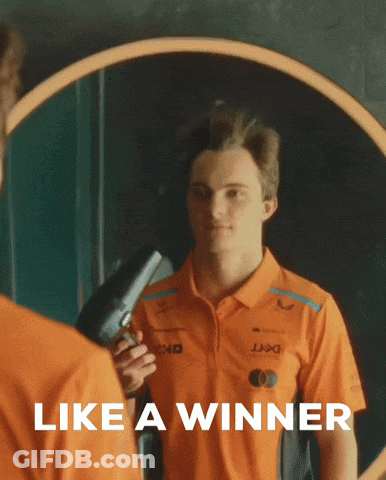 A Man In An Orange Shirt Holds A Hair Dryer In Front Of A Mirror With The Words Like A Winner Below Him GIF