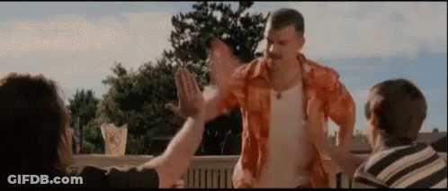 A Man In An Orange Shirt Is Giving A High Five To Two Other People GIF