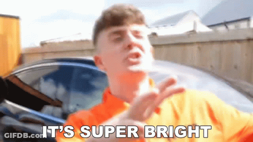 A Man In An Orange Shirt Is Saying It 'S Super Bright . GIF