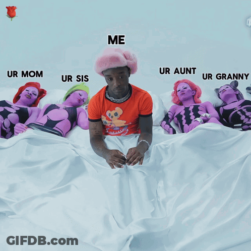 A Man In An Orange Shirt Is Sitting On A Bed Surrounded By Purple Women GIF