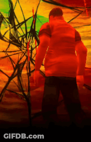 A Man In An Orange Shirt Is Standing In Front Of A Colorful Background GIF