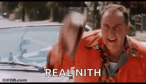 A Man In An Orange Shirt Is Standing Next To A Car And Holding A Hammer . GIF