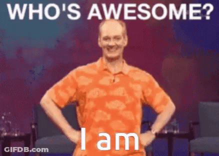 A Man In An Orange Shirt Is Standing With His Hands On His Hips With The Words Who 'S Awesome I Am Below Him GIF