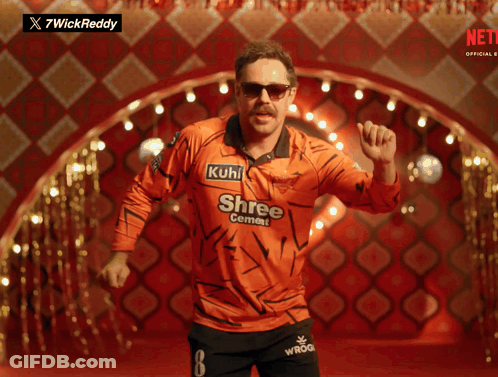 A Man In An Orange Shirt That Says Shree Cement On It GIF