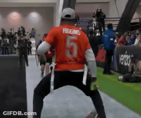 A Man In An Orange Shirt With The Number 5 On The Back GIF