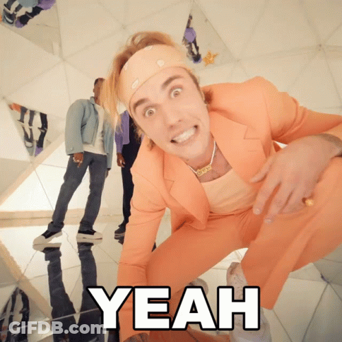 A Man In An Orange Suit Is Kneeling Down With The Word Yeah Below Him GIF