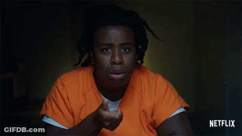 A Man In An Orange Uniform Is Pointing His Finger At The Camera With A Netflix Logo In The Corner GIF