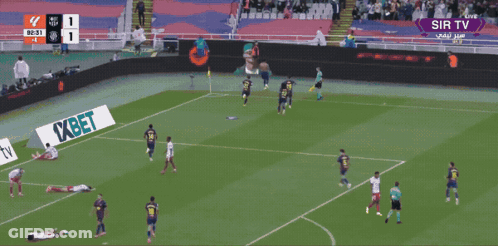A Man In An Orange Vest That Says Barcelona On It Stands In A Stadium GIF