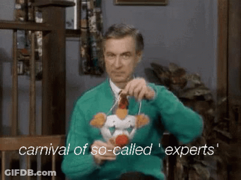 A Man In An Ugly Christmas Sweater Is Holding A Stuffed Chicken On A String . GIF