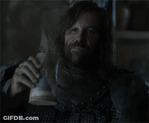 A Man In Armor Drinks From A Wooden Cup GIF