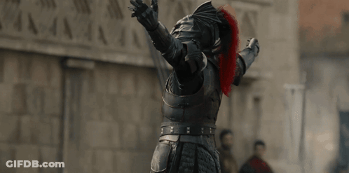 A Man In Armor Has His Arms Outstretched In Front Of A Stone Wall GIF