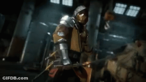 A Man In Armor Is Holding A Sword In His Hand In A Room . GIF