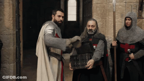 A Man In Armor Is Holding A Treasure Chest GIF