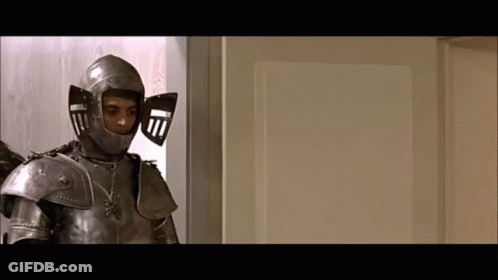 A Man In Armor Is Standing In Front Of A White Door GIF