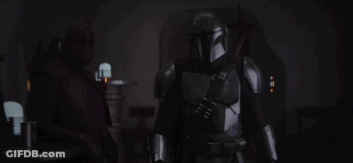 A Man In Armor Is Standing In The Dark GIF