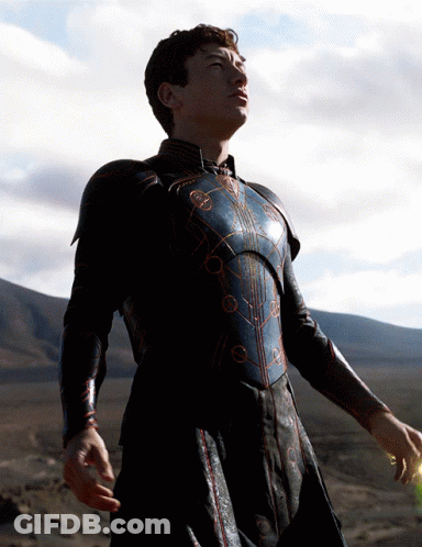 A Man In Armor Stands In A Desert Looking Up At The Sky GIF