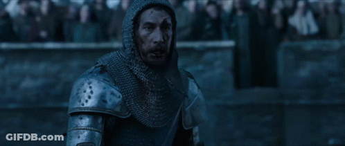 A Man In Armor Stands In Front Of A Crowd Of People GIF