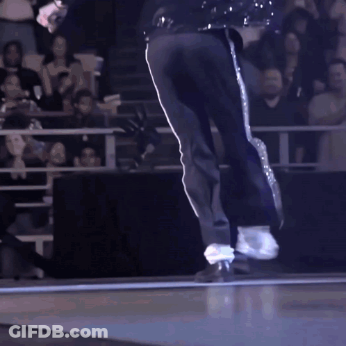 A Man In Black Pants And White Stripes Is Dancing On A Stage GIF