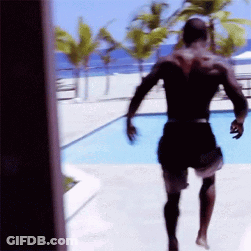 A Man In Black Shorts Is Running Towards A Pool GIF
