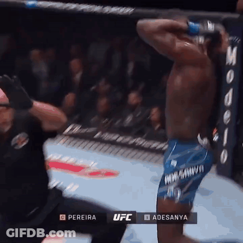 A Man In Blue Shorts Is Kneeling Down In A Boxing Ring During A Ufc Fight GIF
